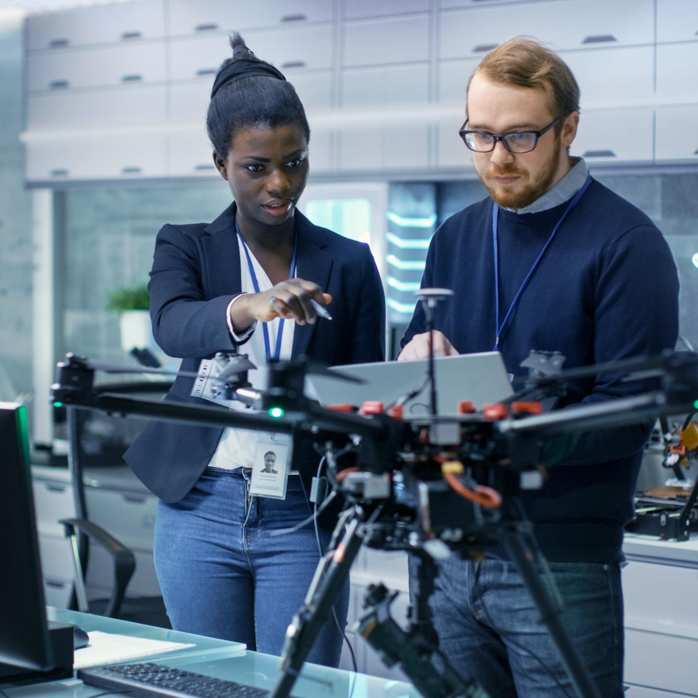 Engineers working on a drone project with help of laptop